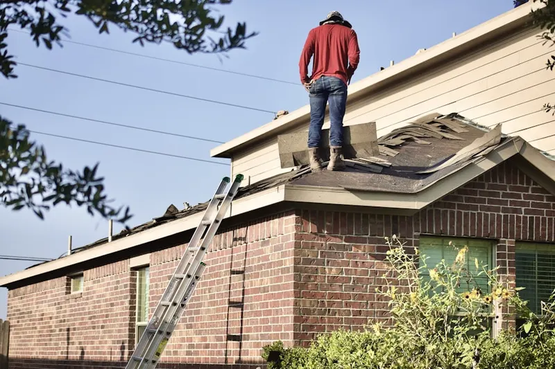 Professional roofer working on a residential roof in Fondren Southwest